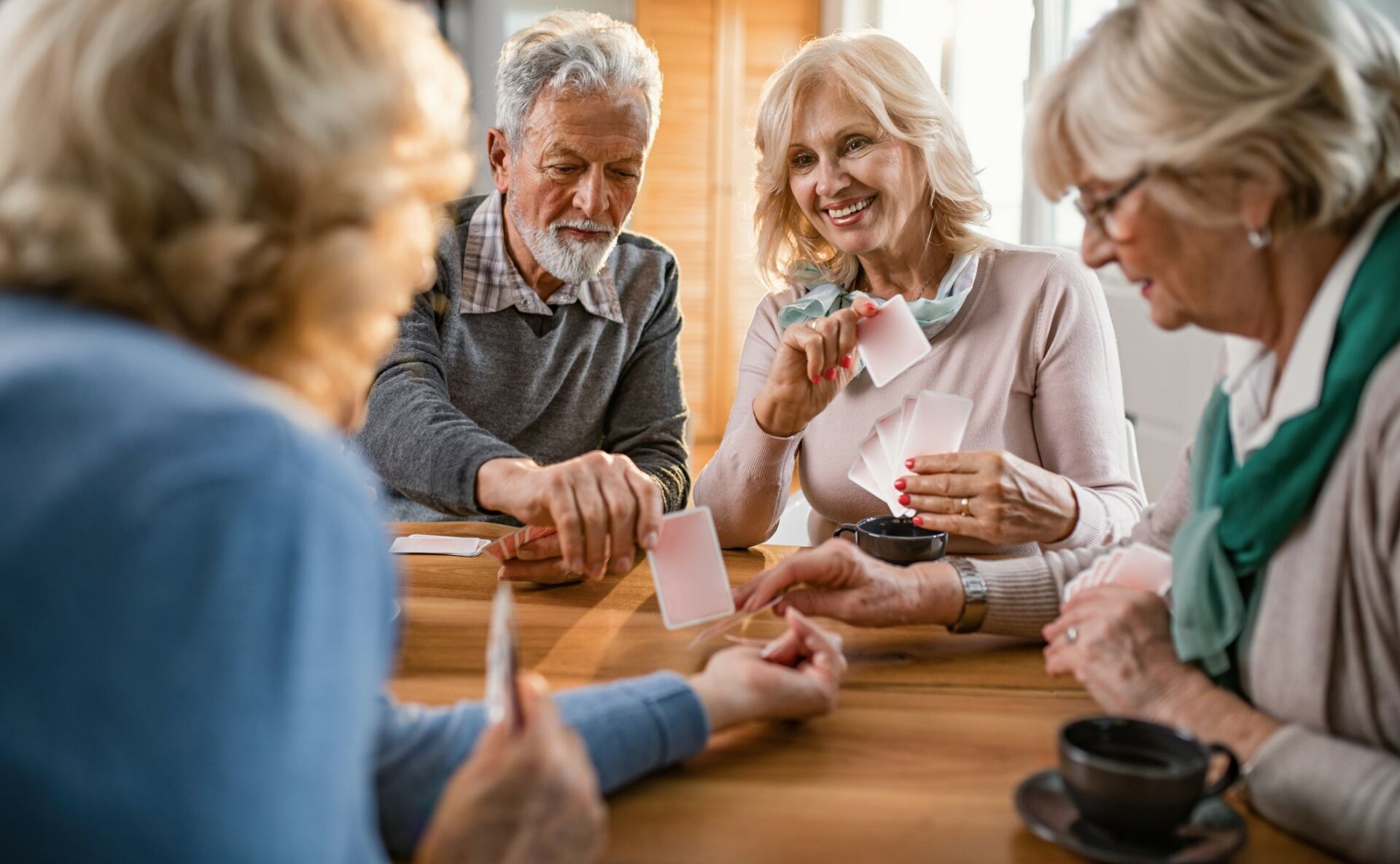 Small group of mature friends enjoying while playing cards